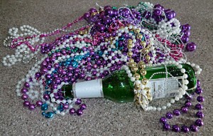 Mardi Gras beads and an empty beer bottle.